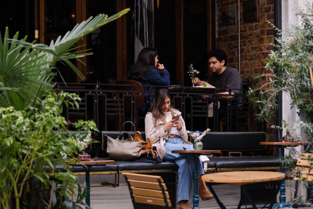 Someone checking their phone at a café terrace